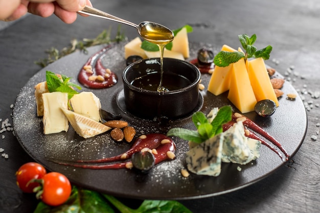 Grande assiette avec assortiment de fromages sur fond de bois