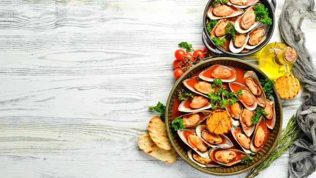 Grande assiette de moules cuites à la sauce tomate avec persil à l'ail et citron Espace libre pour votre texte