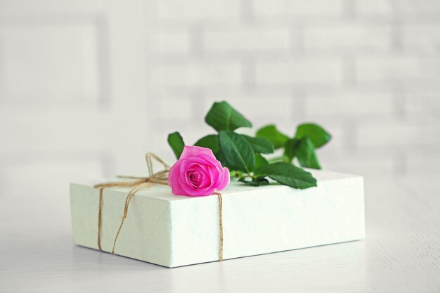 Grande boîte cadeau blanche avec rose sur la table, gros plan
