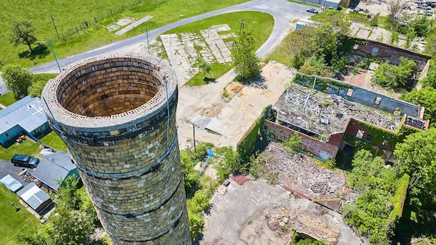 Grande cheminée de silo aérienne près d'un vieux bâtiment en décombres abandonné murs de lierre vert Pierceton IN