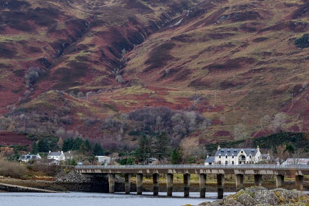 Photo une grande colline avec des maisons dessus et un pont en arrière-plan