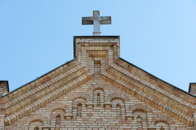 Une grande croix de pierre sur le toit d'une ancienne église