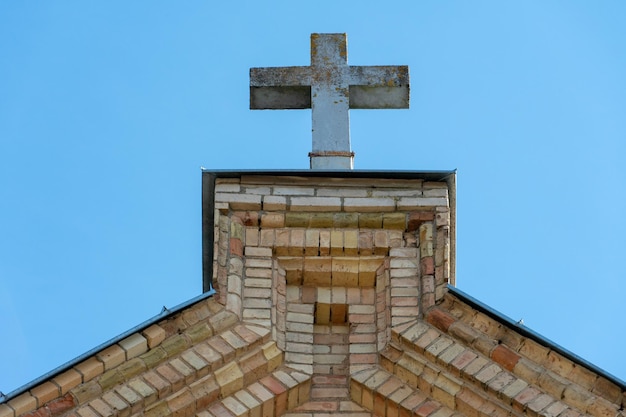 Une grande croix de pierre sur le toit d'une ancienne église