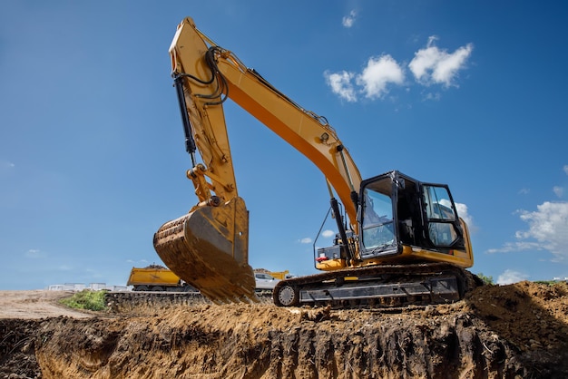 Une grande excavatrice de construction de couleur jaune sur le chantier de construction dans une carrière pour l'extraction de l'image industrielle