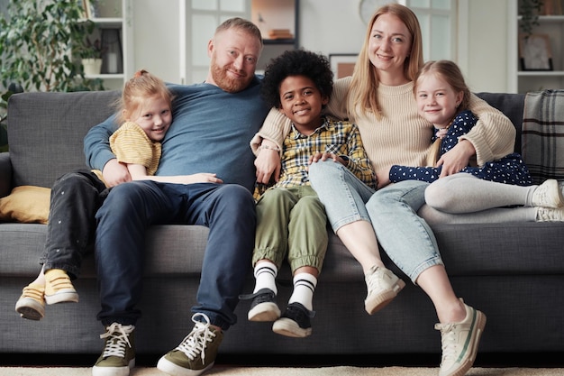 Grande famille adoptive assise à la maison