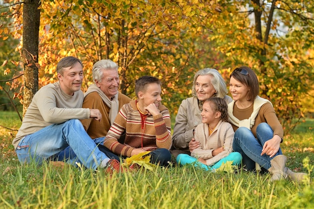 Grande famille heureuse posant dehors en automne