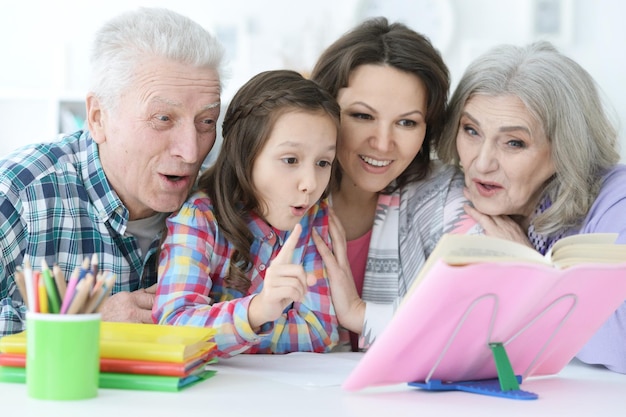 Grande famille avec une petite fille mignonne faisant leurs devoirs ensemble