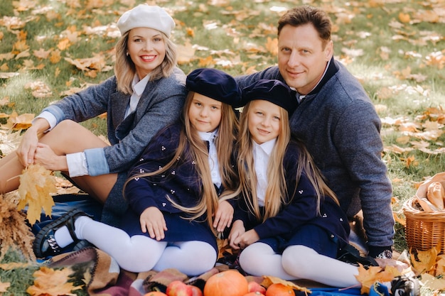 Une grande famille en pique-nique à l'automne dans un parc naturel Des gens heureux dans le parc d'automne