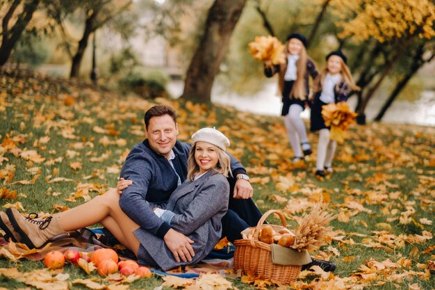 Une grande famille en pique-nique à l'automne dans un parc naturel Des gens heureux dans le parc d'automne