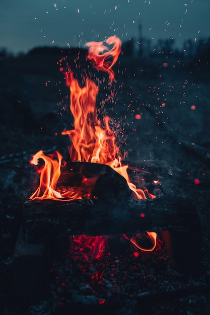 Grande flamme rouge avec des étincelles et bokeh sur le fond sombre