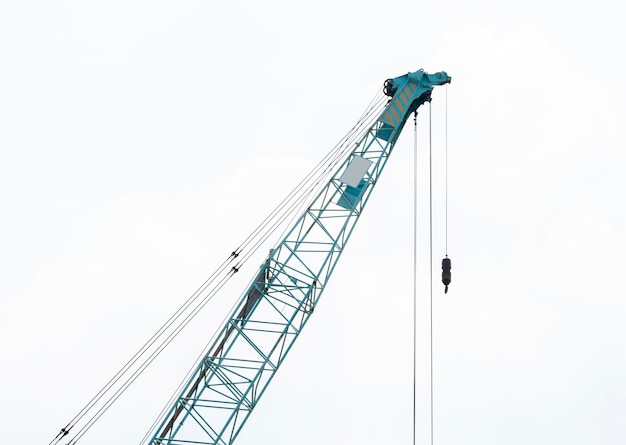 Grande flèche de grue verte avec crochets sur fond de ciel