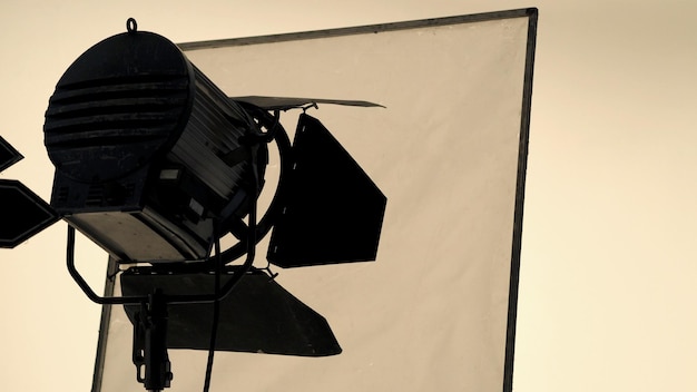 Grande lampe de poche de studio sur trépied et papier softbox dans un studio de grande taille pour la production vidéo ou cinématographique