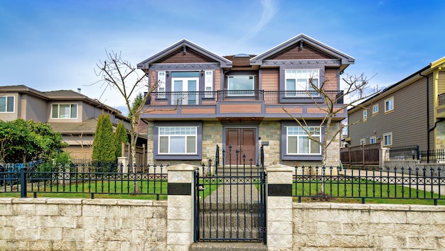 Grande maison résidentielle avec clôture métallique et porte en hiver