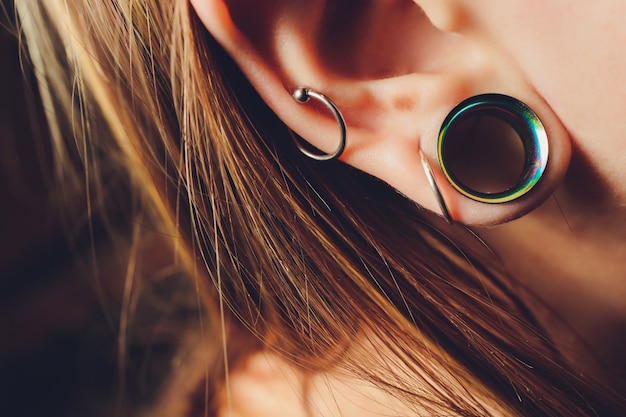 La grande ouverture dans une oreille chez l'adolescent.