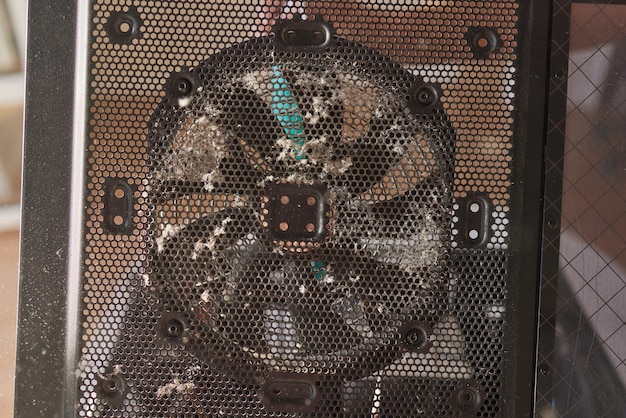 Une grande partie de la poussière sale sur le refroidisseur du processeur de l'ordinateur avec la carte mère et le fragment du boîtier de l'ordinateur Mise au point sélective