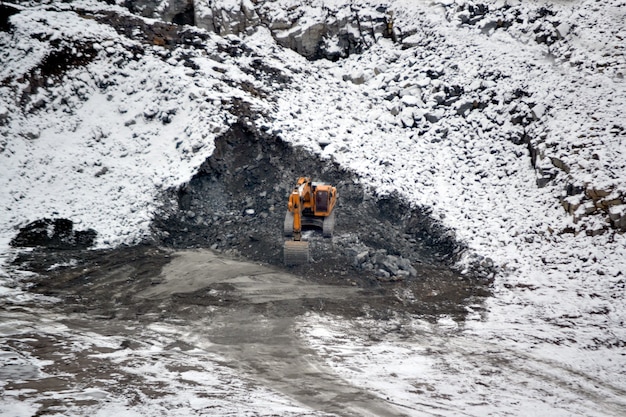 Grande pelle jaune énorme en hiver de carrière de granit