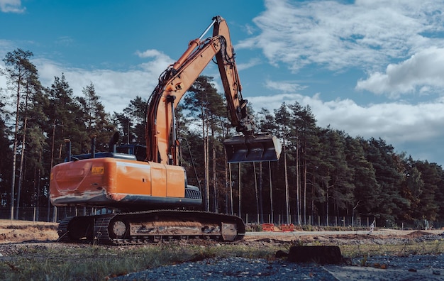 Grande pelle orange prête à travailler pour construire une nouvelle autoroute