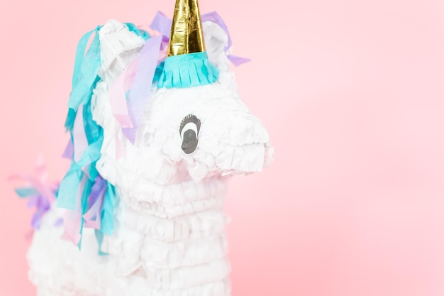 Photo grande pinata licorne sur fond rose.