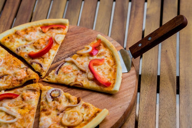 Grande pizza sur une table en bois.