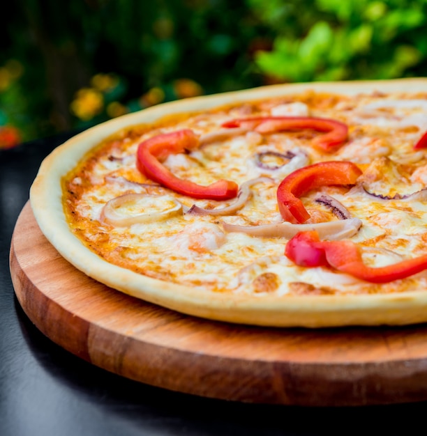 Grande pizza sur une table en bois.