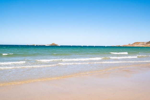 Grande plage de sable de la commune de Sables d'or les pins en Bretagne à marée basse en été