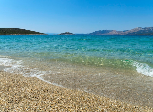 Grande plage de sable de la mer Égée avec les vacanciers et les touristes sur l'île d'Eubée en Grèce