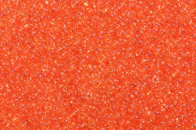 Grande quantité de perles de rocaille orange. Photo haute résolution.