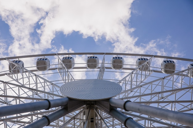 Photo grande roue blanche contre le ciel bleu lumineux, vue de dessous. concept de divertissement.