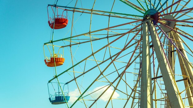 Grande roue avec cabines colorées sur fond de ciel bleu