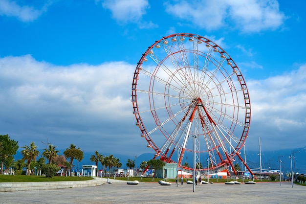 La grande roue est rouge et blanche contre le ciel