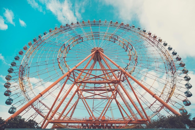 Grande roue sur fond de ciel nuageux couleur vintage.