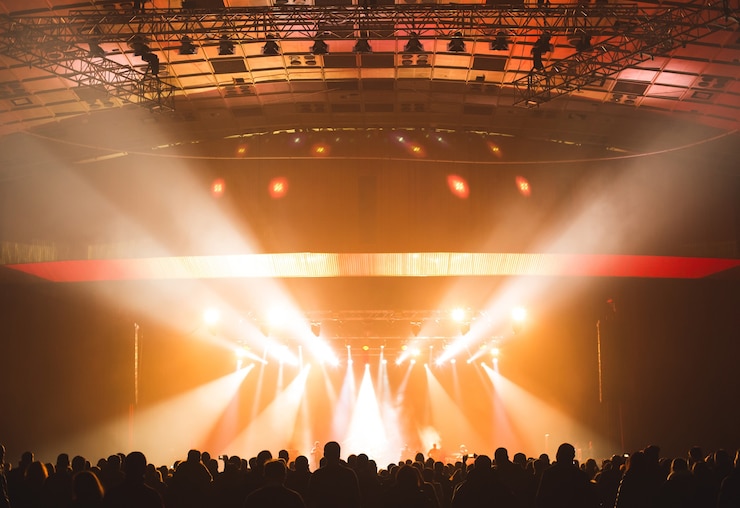Photo grande salle de concert remplie de spectateurs avant la scène