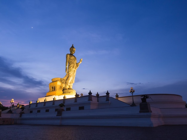 Grande statue de bronze de bouddha marchant dans la province bouddhiste de Phutthamonthon en Thaïlande au crépuscule