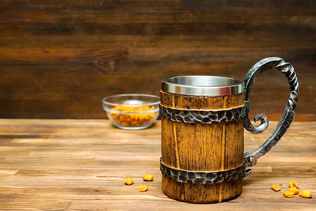 Grande tasse brune de beerale et de collations croustillantes bretzels maïs noix dans un bol sur fond de table en bois gros plan Alcool bar à cocktails boisson alcool fête concept maquette modèle copie espace