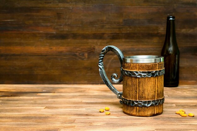 Grande tasse brune de bouteille de beerale et collations croustillantes bretzels maïs noix dans un bol sur fond de table en bois gros plan Alcool bar à cocktails boisson alcool fête concept maquette modèle copie espace