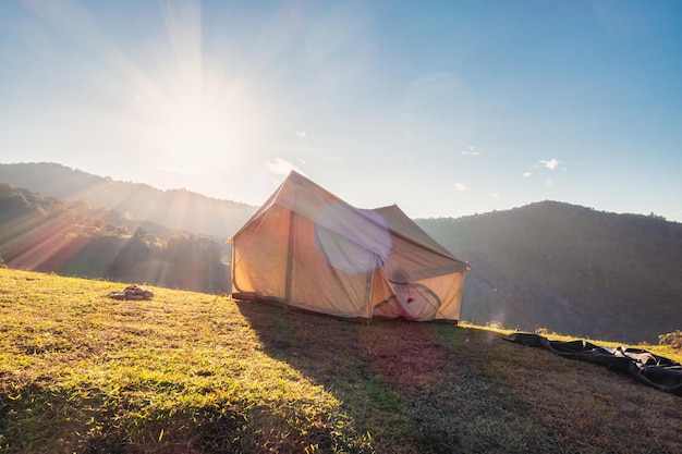 Grande tente camping avec soleil sur la colline du camping à la campagne le soir