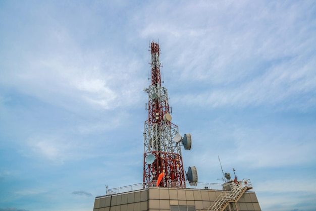 Grande tour de télécommunication contre le ciel et les nuages en arrière-plan