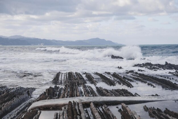 une grande vague s'écrasant sur un rivage rocheux