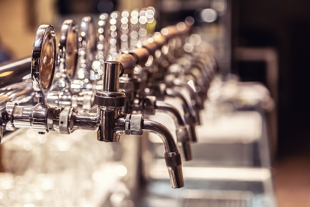 Grande variété de pipes à bière pression dans un pub prêt à servir de la bière.