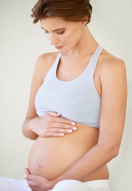 Photo de grandes attentes une belle jeune femme enceinte regardant son ventre nu