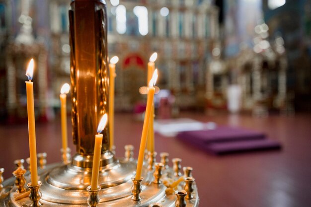 De grandes bougies brûlent à l'intérieur de l'église orthodoxe