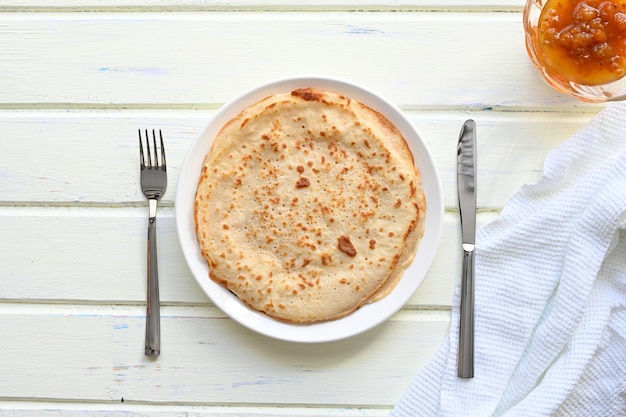 Grandes crêpes à la confiture sur fond blanc.