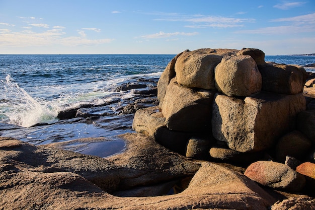 De grandes formations de rochers sur la côte de l'océan du Maine avec des vagues se brisant