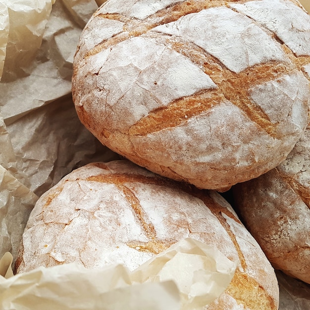 Photo de grandes miches rondes de pain de seigle reposent sur le comptoir du magasin.