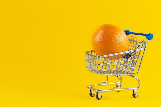 Grandes oranges lumineuses dans le panier pour faire du shopping