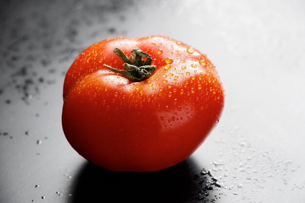 Photo de grandes tomates rouges mûres avec des gouttes d'eau des légumes de saison pour une alimentation saine