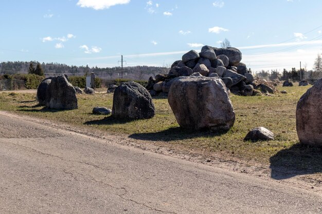 De grands blocs de pierre empilés sur le côté d'une route de gravier et un tas de pierres en arrière-plan