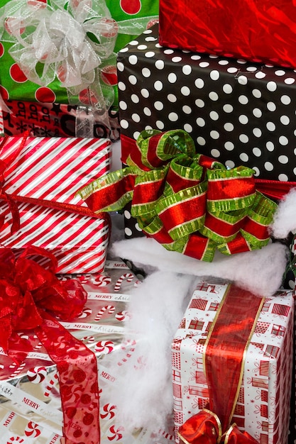 Grands cadeaux emballés dans des papiers colorés avec des arcs en tas prêts pour Noël.