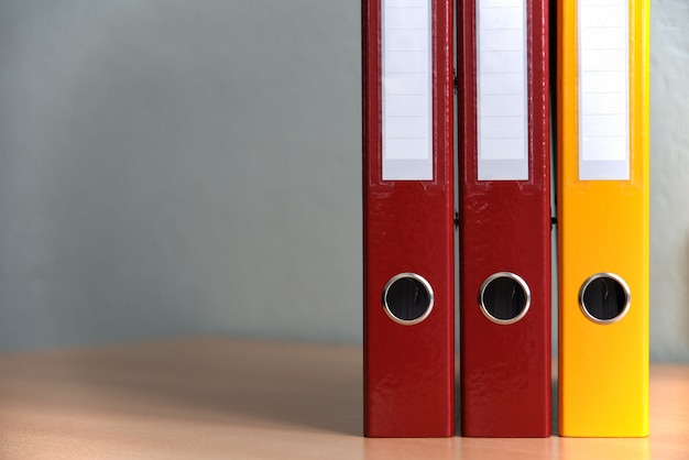 Grands dossiers de couleurs pour les documents sur la table au bureau, gros plan, espace de copie