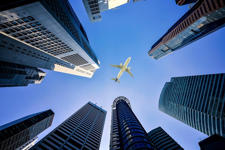 Photo grands immeubles de la ville et un avion survolant